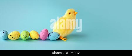 Easter decoration of a yellow chick with a row of colorful painted Easter eggs Stock Photo