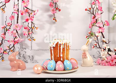Abstract Easter composition featuring a traditional Russian meringue kulich and decorated eggs on an elegant kitchen table with spring cherry blossoms Stock Photo