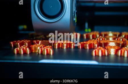 3D printer. 3D printer printing object close-up. 3D printer printing model orange color. Working 3D printer. Concept printing technology. New modern additive progressive technology. FDM technologies Stock Photo