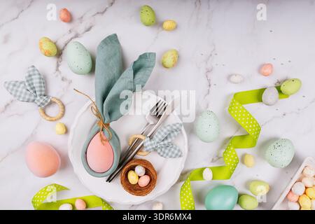 Easter Table Arrangement with Bunny Napkin and Green Ribbon Stock Photo