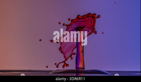 Color drops splash with umbrella or balls in fresh clean water Stock Photo