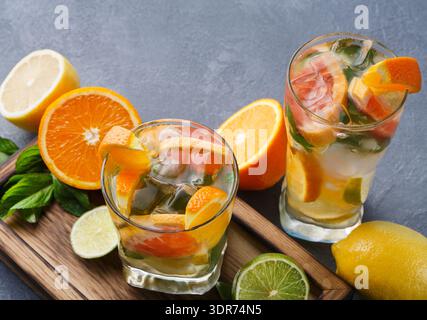 Refreshing Summer Drinks With Citrus on a Wooden Board in a Bright Kitchen Setting Stock Photo