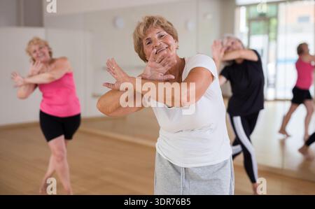 Energetic elderly woman practicing vigorous dance movements Stock Photo
