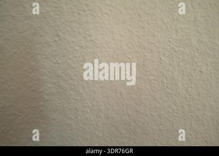 Close-up of a light beige textured wall with subtle rough plaster finish, creating a minimal and neutral background suitable for interior design, cons Stock Photo
