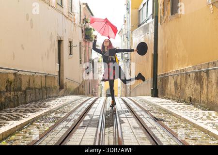 Young woman balancing on tram tracks in old city Stock Photo