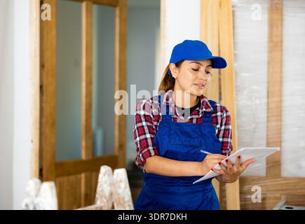 Woman builder inspecting construction site in new apartment Stock Photo