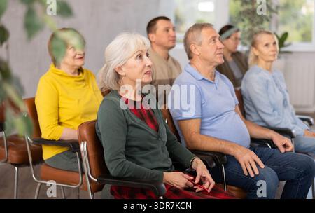 Group of older students sitting and listening at lesson Stock Photo