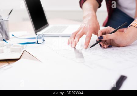 People Working Together on Architectural Plans in a Meeting Room During the Day Stock Photo