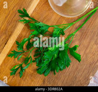 Parsley sprigs on wooden cutting board Stock Photo