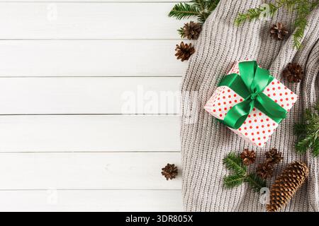 Gift Wrapped in Red and White Polka Dots With Green Ribbon on a Cozy Knit Blanket Stock Photo