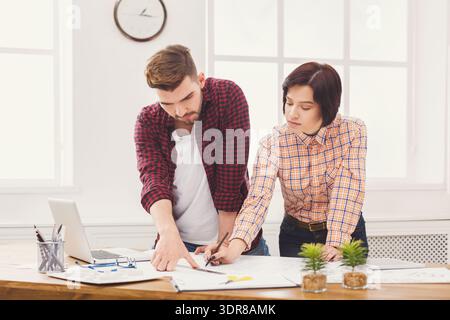 Team Collaborates on Design Project in Modern Office Space During Daylight Hours Stock Photo