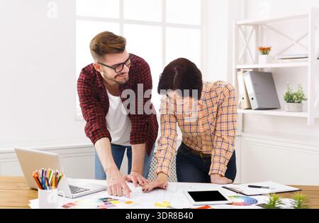 Design Team Collaborates on Project at a Bright Office Space During the Day Stock Photo