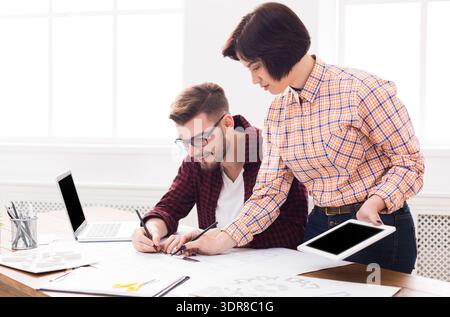 Two People Working on Design Projects in a Bright Office During Daytime Hours Stock Photo