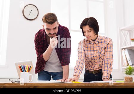 Colleagues Discussing Project Plans in a Bright Office Space During Daytime Hours Stock Photo