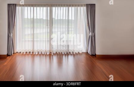 Interior of empty living room with large bright window and white curtains in empty room Stock Photo