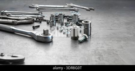 Open end wrench , socket wrench and nuts on steel work bench Stock Photo