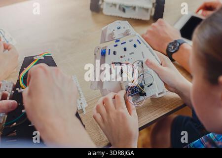 Participants Work on Building a Robot at a Workshop in a Classroom Setting During the Day Stock Photo