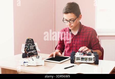 Student Works on Robotics Project and Uses Tablet for Programming and Control Stock Photo