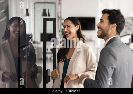 Coworkers laughing while planning project in modern office Stock Photo