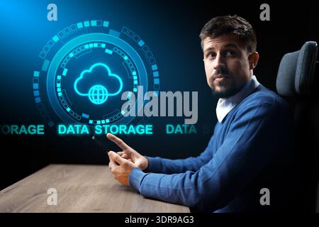 Man using smartphone with cloud data storage graphic at his workplace Stock Photo