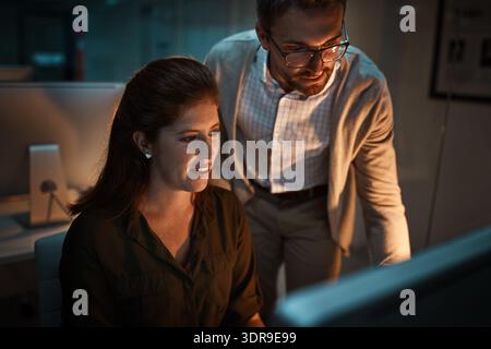 Night, manager and employee with computer in office, project feedback and collaboration for improvement. Advice, mentoring and people with pc for Stock Photo