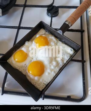 Fried eggs in cast iron pan Stock Photo