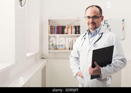 Medical Professional Poses in Office Setting With Clipboard and Stethoscope Stock Photo