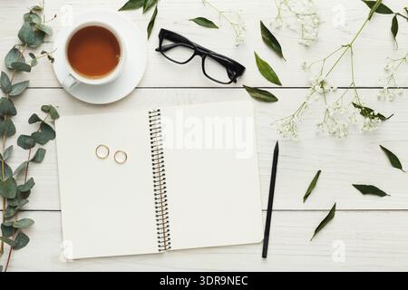 Collage of a Cup of Tea, Notebook, Glasses, and Flowers Arranged on a Wooden Table Stock Photo