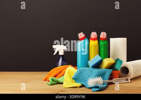 Cleaning Supplies Displayed in a Set on a Wooden Table With a Dark Background Stock Photo