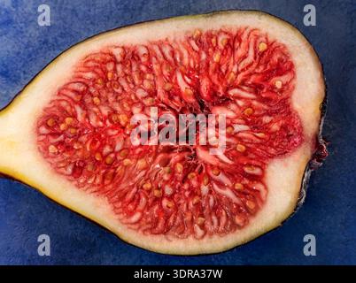 Fresh slice of figs on blue background is insulated. Stock Photo