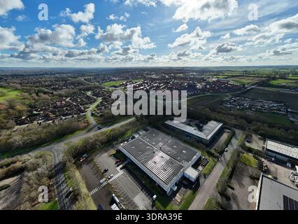Aerial view of a modern data center complex under a bright sky with scattered clouds, nestled among trees and roads, Milton Keynes, United Kingdom. Stock Photo