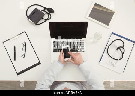Collection of Tools and Devices Used in a Medical Setting With a Person Working at a Desk Stock Photo