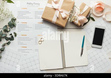 Collection of Wedding Planning Items on a Table With Checklist, Gifts, and Calendar Stock Photo