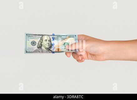 Hand holding a 100 dollar bill. Man hand is holding dollar bill. Money, cash. Hand taking a banknote of 100 dollar. Woman's hand holding one hundred Stock Photo