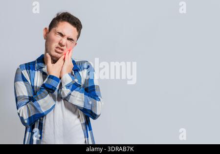 Man suffering with toothache or pulpitis. Concept of people suffering from toothache, Young man with sensitivity and toothache i Stock Photo