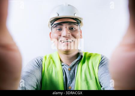 Smiling male engineer taking a selfie looking at camera. Cheerful builder engineer taking a selfie isolated, Engineer taking a s Stock Photo