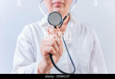 Female doctor hand showing stethoscope isolated. Female doctor holding stethoscope on white background Stock Photo