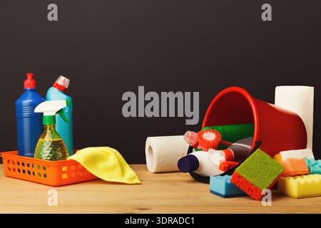 Cleaning Supplies and Tools Arranged in a Collage on a Wooden Surface in a Simple Setting Stock Photo