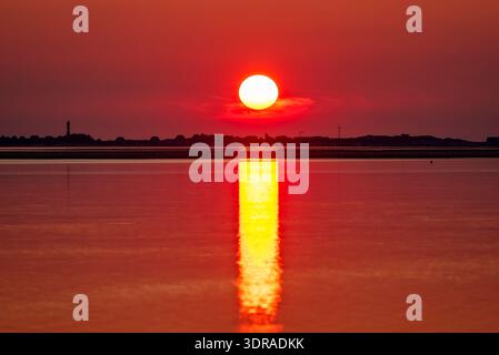 Setting sun over the North Sea island of Sylt as seen from the island of Föhr Stock Photo