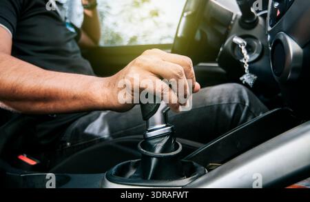 Concept of hand grabbing the gear lever of a car with copy space, Close-up of driver hand on the gear lever of a car, close-up o Stock Photo