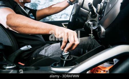 Close-up of driver hand on the gear lever of a car, concept of hand grabbing the gear lever of a car, close-up of hands accelera Stock Photo