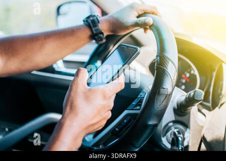 Person in his car using cell phone, Close up of driver hands using his phone, Concept driver hands touching cell phone screen Stock Photo