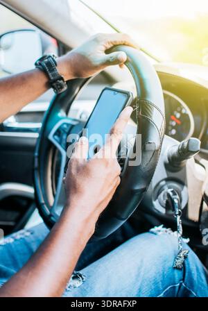 Close up of driver hands using his phone, Concept driver hands touching cell phone screen, Person in his car using cell phone Stock Photo