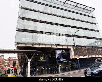 Manchester, UK - January 26, 2026: Car parking glass facade dominates Manchester Shudehill Interchange city scene with vehicles and pedestrians at a b Stock Photo