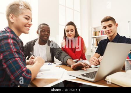 Group of Friends Collaborating on a Project in a Bright Room With a Laptop Stock Photo
