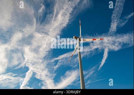 Rotor blades of a wind turbine in front of a blue sky with contrails and cirrus clouds Stock Photo