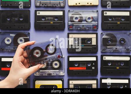 Collection of Cassette Tapes Arranged in a Mosaic Pattern With One Tape Being Held Stock Photo