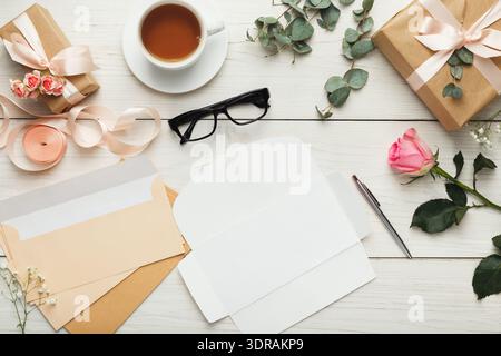 Creative Workspace With Gifts, Flowers, Tea, and Stationery Arranged Neatly on a Wooden Table Stock Photo