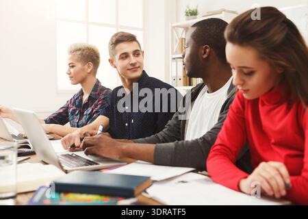 Group of Students Working Together on Computers in a Classroom Setting in Daytime Stock Photo