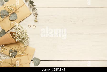 Collection of Envelopes and Flowers Arranged on a Wooden Table for an Event Stock Photo